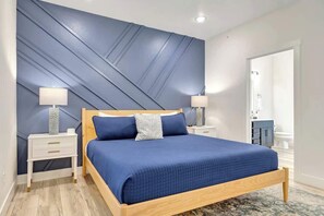 A bedroom with a bed, nightstands, and a bathroom door. - SDC | Lake View | Pools·Hot Tub·Sauna | Theater Rm (MARVEL CAV PK)