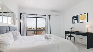 Habitación de hotel moderna con una cama grande, un escritorio y vistas a la ciudad.