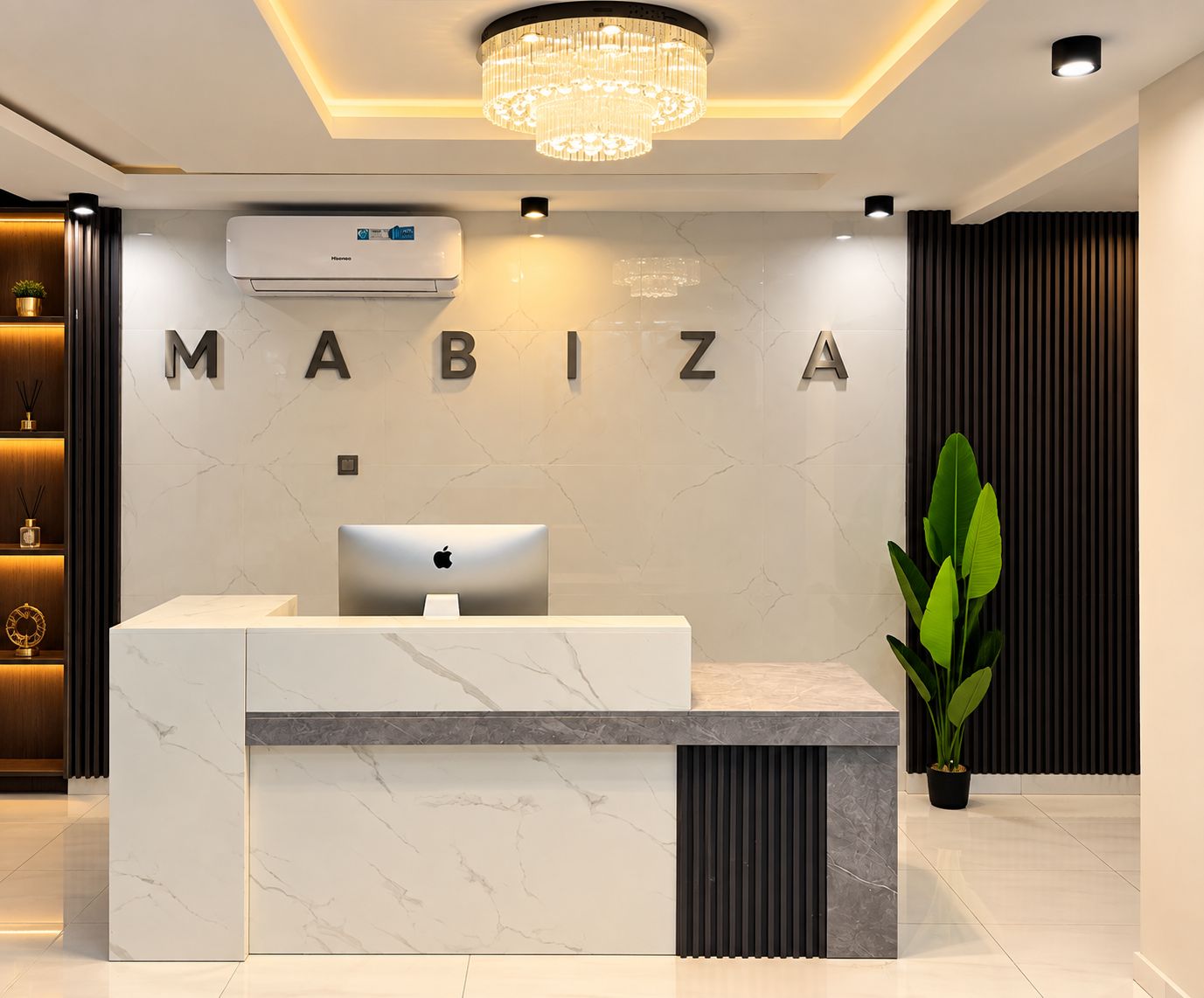 Un comptoir d’accueil doté d’un plateau en marbre et d’un design moderne, avec le nom « MABIZA » inscrit sur le mur qui le surplombe.