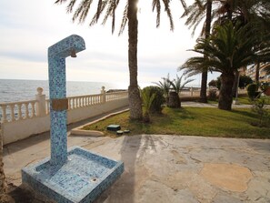 A pool with a mosaic design, surrounded by palm trees and a view of the sea. - APARTAMENTO VORAMAR by Interhome (Alicante)