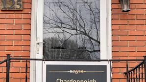 Un edificio de ladrillo con un letrero que dice 'Chardonleigh' y el número '125' encima.
