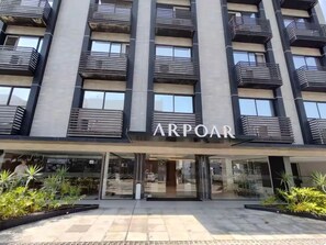 Ein mehrstöckiges Gebäude mit Balkonen und einem Schaufenster mit der Aufschrift 'ARPOAR'.