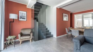 Una sala de estar moderna con una escalera, un comedor y un sofá.