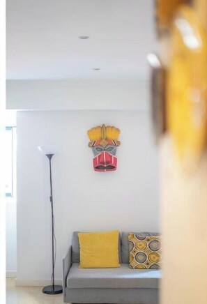 Ein modernes Wohnzimmer mit einer Couch, einer Stehlampe und einer Wandmaske.