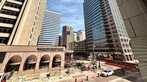 Une vue urbaine avec de hauts immeubles, un restaurant McCormick et des barrières de chantier.