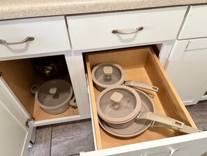 A kitchen drawer with pots and pans.