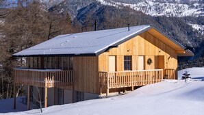 A wooden cabin with a balcony, surrounded by snow-covered mountains and trees. - La Tzoumaz Lodge, 4 Vallées luxury chalet, daily housekeeping, sleeps 10 to 12 (Riddes)