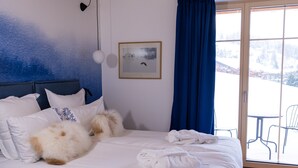 A bedroom with a wooden ceiling, a bed with white bedding, a desk with a chair, and a view of a snowy landscape through a glass door. - La Tzoumaz Lodge, 4 Vallées luxury chalet, daily housekeeping, sleeps 10 to 12 (Riddes)