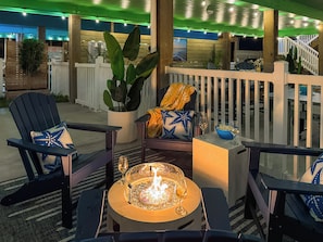 Eine Terrasse mit Sitzgelegenheit im Freien, einer Feuerstelle und Blick auf den Ozean.