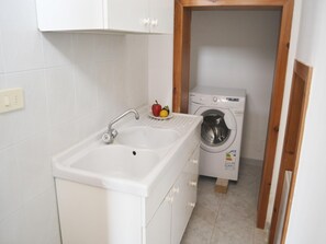 A small laundry room with a washing machine and a sink. - Casa Vacanze Chikai a 230 Metri Dalla Spiaggia Li Marangi di San Foca (Melendugno)