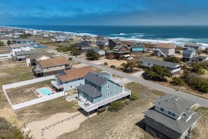 Una zona residencial costera con casas, una piscina y vistas al océano.