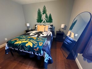 A bedroom with a bed, two bedside tables, a mirror, and a wall decal. - Hide & Seek Lodge I Cozy 2BR I 15m to RRG I Wi-Fi (Stanton)