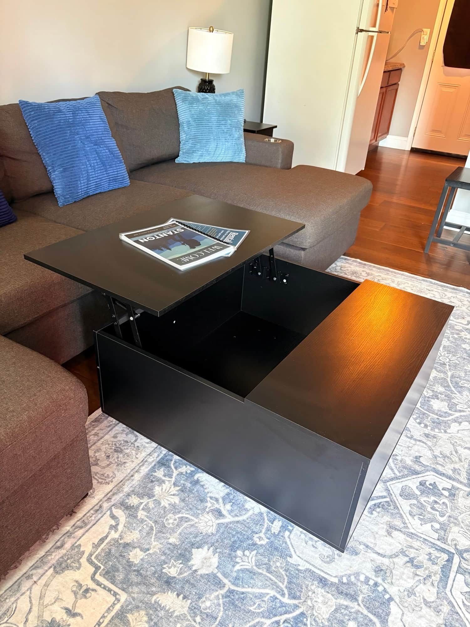 Ein modernes Wohnzimmer mit einem Ecksofa, einem Couchtisch und einem Teppich.
