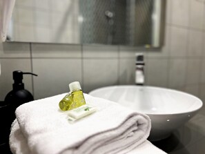 A bathroom with a white sink, a towel, and a bottle of liquid soap. - Appartement 6B - MyResidenced'Azur (Beausoleil)