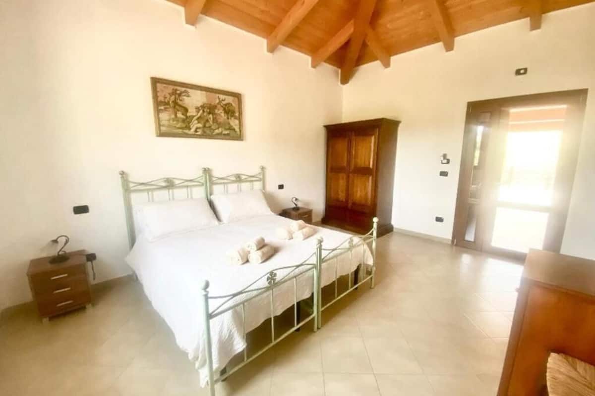 Un dormitorio con cama, armario de madera y un cuadro en la pared.