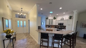 A kitchen with a central island, white cabinetry, and a chandelier. - Luxury Golf Retreat w/pool in The Villages/Golf Cart Included/Prime Location (The Villages)