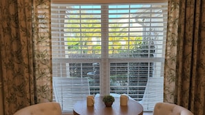 A room with a window, two chairs, a small table, and a potted plant. - Luxury Golf Retreat w/pool in The Villages/Golf Cart Included/Prime Location (The Villages)
