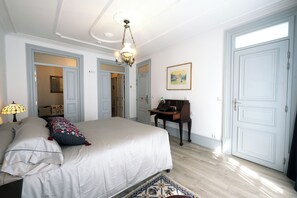 Une chambre à coucher avec un lit, un bureau, une chaise et une porte.