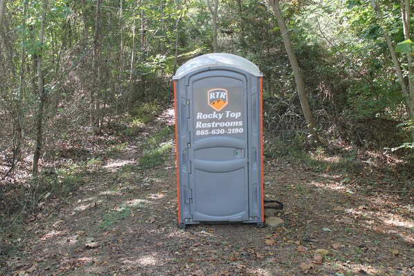 Un baño portátil con la leyenda 