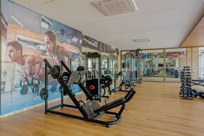 A gym with exercise equipment, a mirror wall, and a wooden floor. - RV12 Beautiful and Cozy Studio in Rio Vermelho (Salvador)