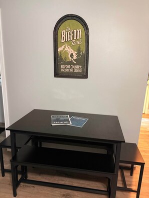 A black table with a framed sign above it.