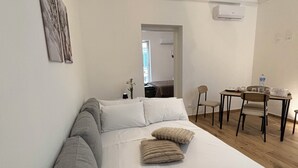 Quarto com cama grande, uma escrivaninha e uma cadeira.