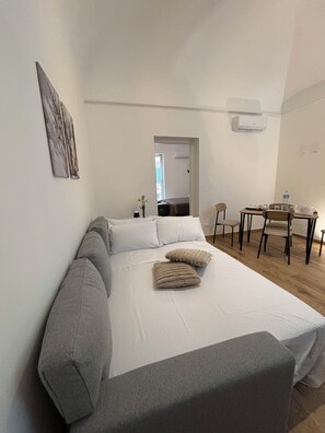 A bedroom with a large bed, a desk, and a chair. - Dimidiuim suites apartment a stone's throw from the center of Palermo. (Palermo)