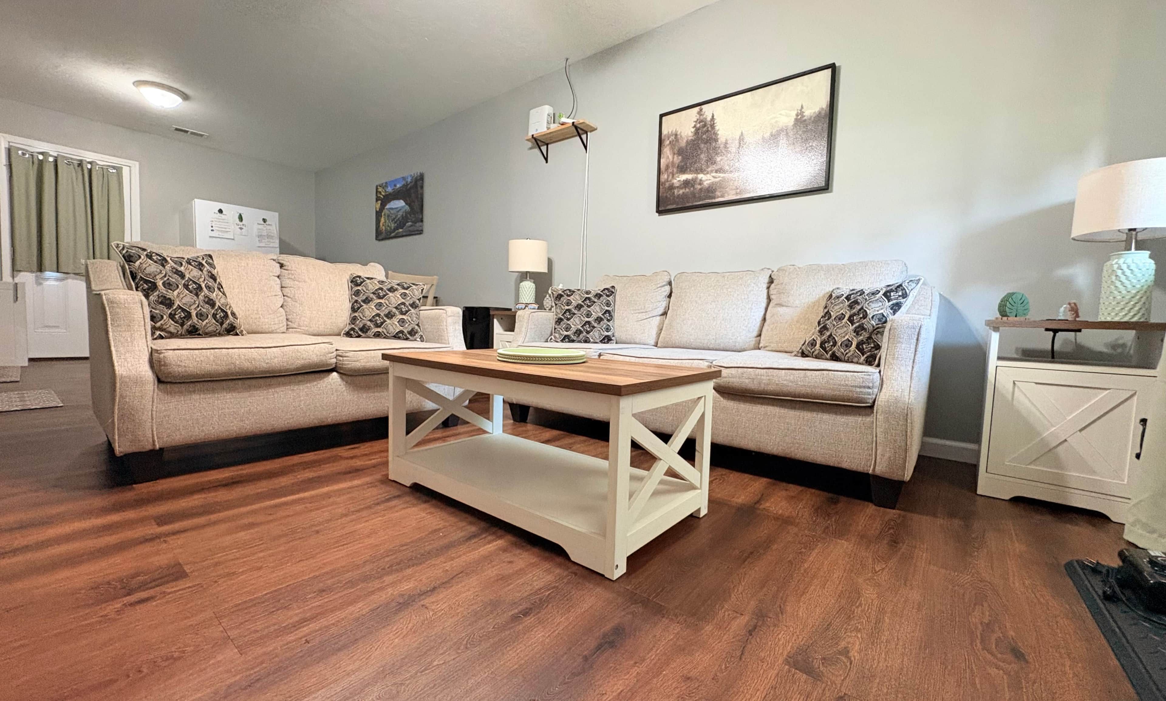 A living room with two sofas, a coffee table, a lamp, and a cabinet.