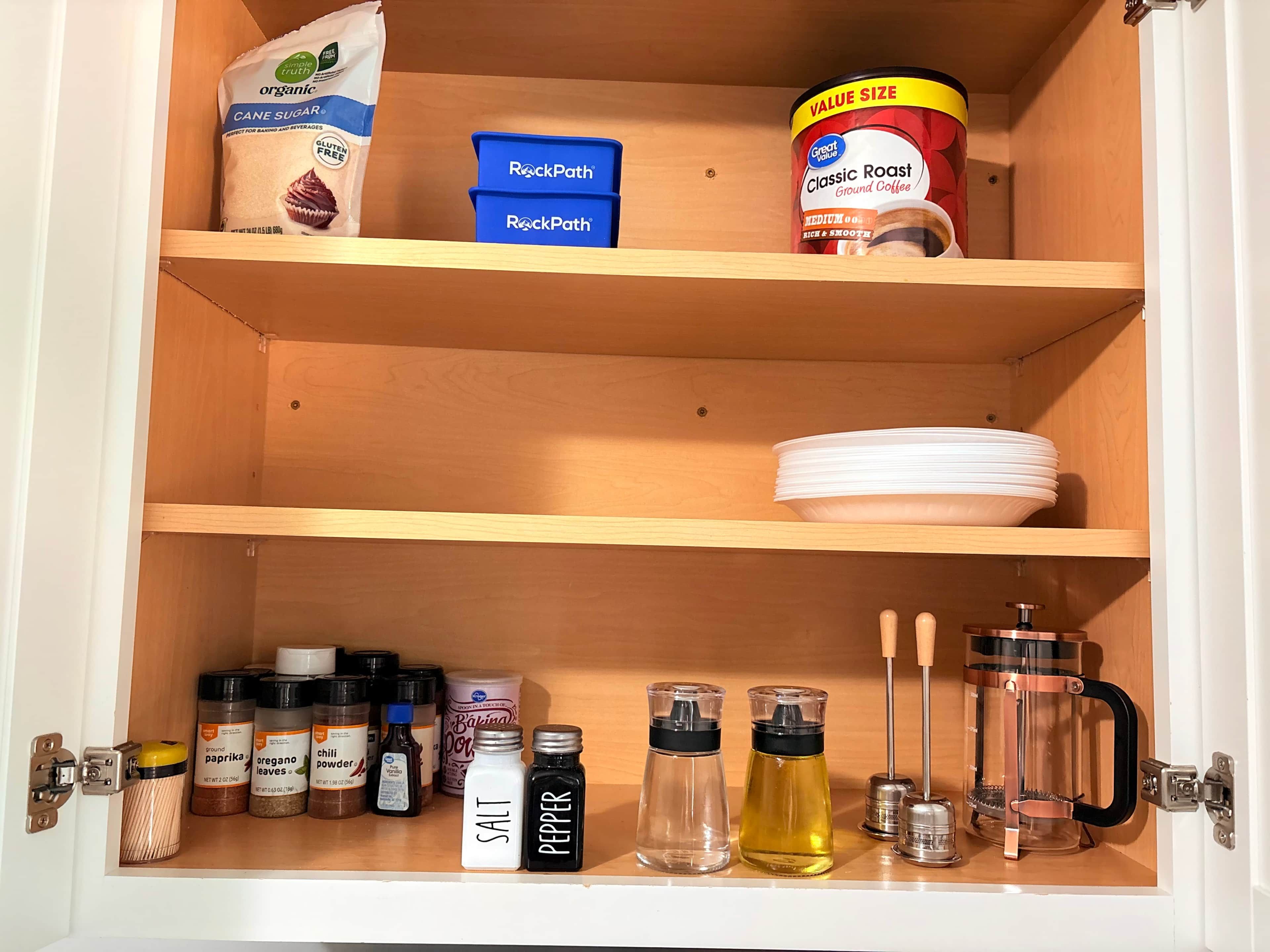 Ein Küchenschrank mit Regalen voller Lebensmitteln und Küchenutensilien.