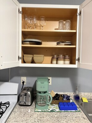 A kitchen with a coffee maker, toaster, and various kitchen items on the counter.