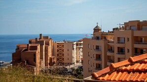 A coastal residential area with buildings, a view of the sea, and a clear sky. - Appartement 4A - MyResidenced'Azur (Beausoleil)