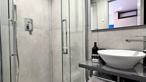 A modern bathroom with a glass-enclosed shower, a white sink, and a mirror above the sink. - Appartement 4A - MyResidenced'Azur (Beausoleil)
