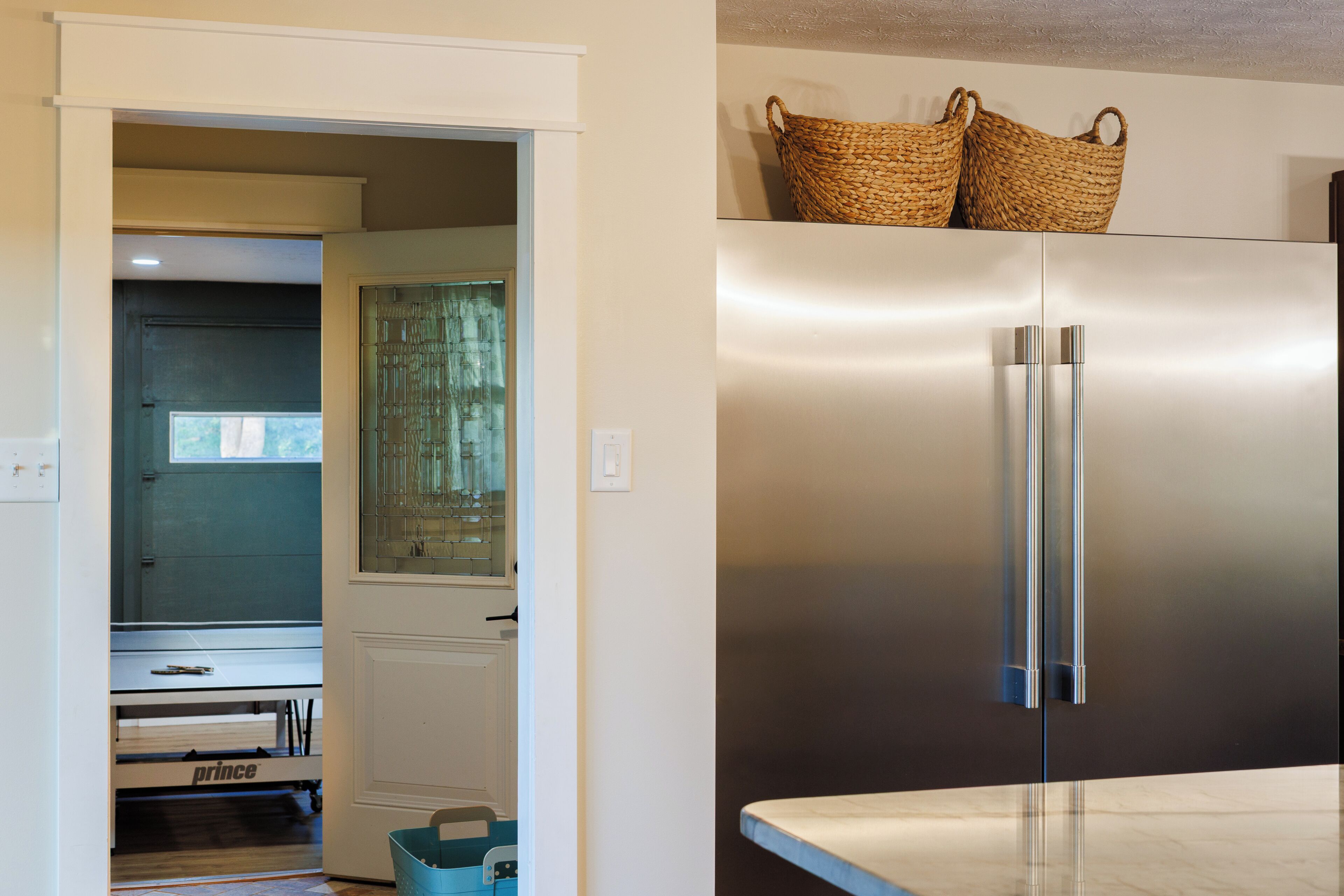 A modern kitchen with a stainless steel refrigerator, a built-in oven, and a microwave.