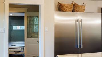 A modern kitchen with a stainless steel refrigerator, a built-in oven, and a microwave.