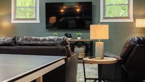 A living room with a TV, a sofa, a small table, and a lamp. - Wonderful 4-bedroom house with AC in charming Lafayette (Lafayette)