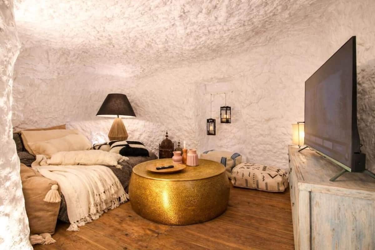 Una habitación acogedora con una mesa redonda para café, un sofá, un televisor y elementos decorativos.