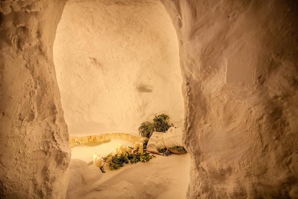 Una cueva de hielo con un pequeño árbol y velas.
