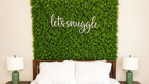 A bed with white bedding, two nightstands with lamps, and a green wall with a 'lets snuggle' sign. - Muddy Boots HideoutI Cozy 2BR I 15m to RRG I Wi-Fi (Stanton)