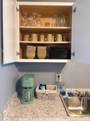 A kitchen with a coffee maker, a basket of groceries, and a sink. - Muddy Boots HideoutI Cozy 2BR I 15m to RRG I Wi-Fi (Stanton)