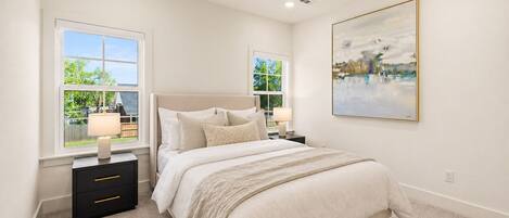 A bedroom with a bed, nightstands, a ceiling fan, and a painting on the wall.