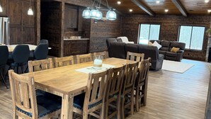 Un interior rústico con una mesa de comedor de madera, sillas, un sofá y una chimenea.
