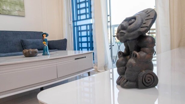 A modern living room with a sofa, a coffee table, and a decorative sculpture.
