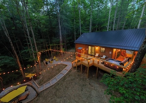 Eine Hütte mit Terrasse, Sitzgelegenheiten im Freien und Lichterketten.