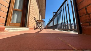 Ein Gebäude aus Backsteinen mit einem Metallgeländer, blauem Himmel und einem gepflasterten Weg.