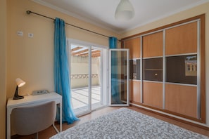 A room with a desk, chair, and a large sliding door to a balcony. - Villa 'Casa Da Arrabida' with Mountain View, Wi-Fi and Air Conditioning (São Simão)