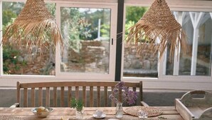Een houten tafel met een kom, een kopje, een boek en een vaas met bloemen.