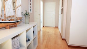 A hallway with a model ship on a shelf, a potted plant, and a door at the end. - 4 Star Holiday Home in Grebbestad (Grebbestad)