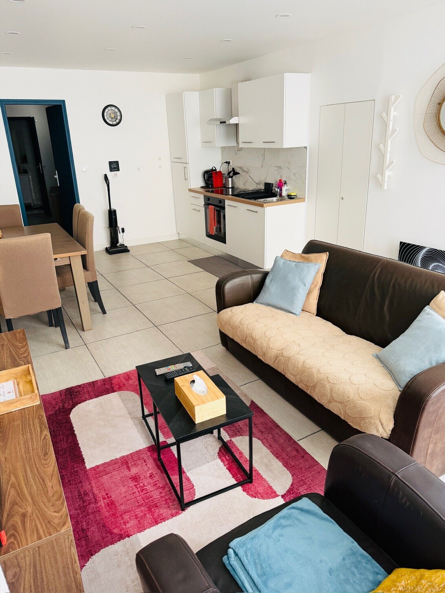 Un salon moderne avec un canapé, une table basse et un coin repas avec des chaises.