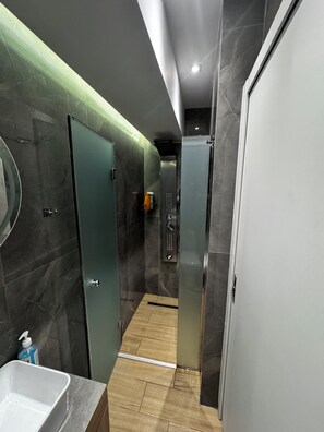 A modern bathroom with a marble wall, a sink, and a shower area. - Athens Stay 50 Dual Private Suites Dual Baths (Athina)