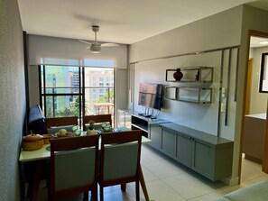 A modern kitchen with a dining area, large windows, and a ceiling fan. - Buenos Aires 504 - Apartment in the best location in Tambaú for 6 people. (João Pessoa)